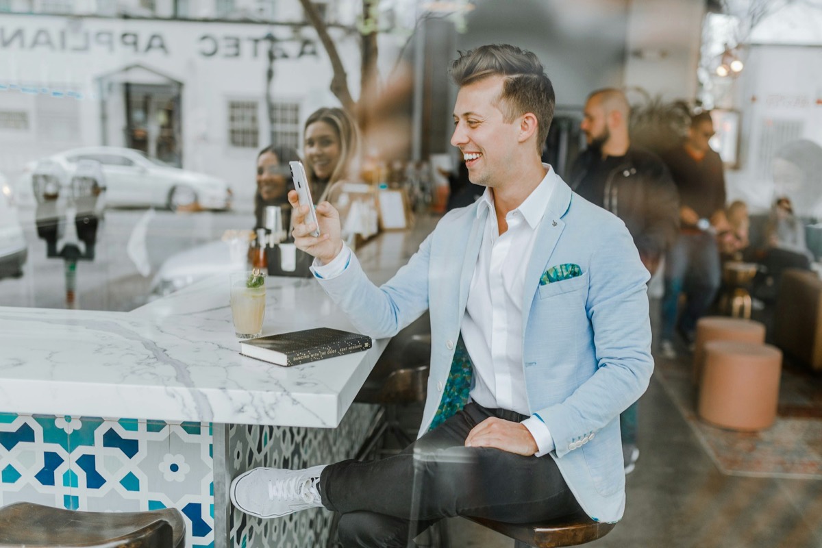 Cliente sonriendo mientras recibe una respuesta en su celular